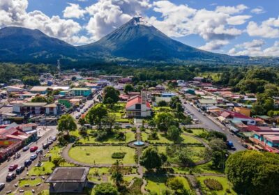 Aerial view of La Fortuna Town with Arenal Volcano in the background on a sunny day in Costa Rica