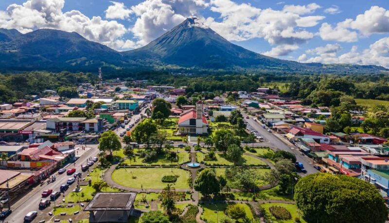 Aerial view of La Fortuna Town with Arenal Volcano in the background on a sunny day in Costa Rica