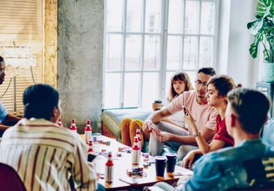 A bunch of backpackers hanging out at a hostel in the common area