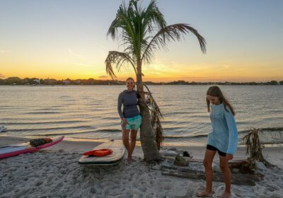 people standing next to palm trees on the beach